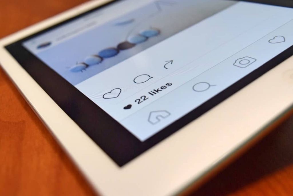 - פרסום ישראל Tablet screen displaying a social media post with 22 likes and icons for like, comment, and share on a white interface